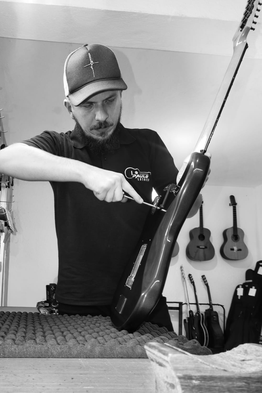 Ajuste fino da ponte de uma guitarra vermelha na oficina